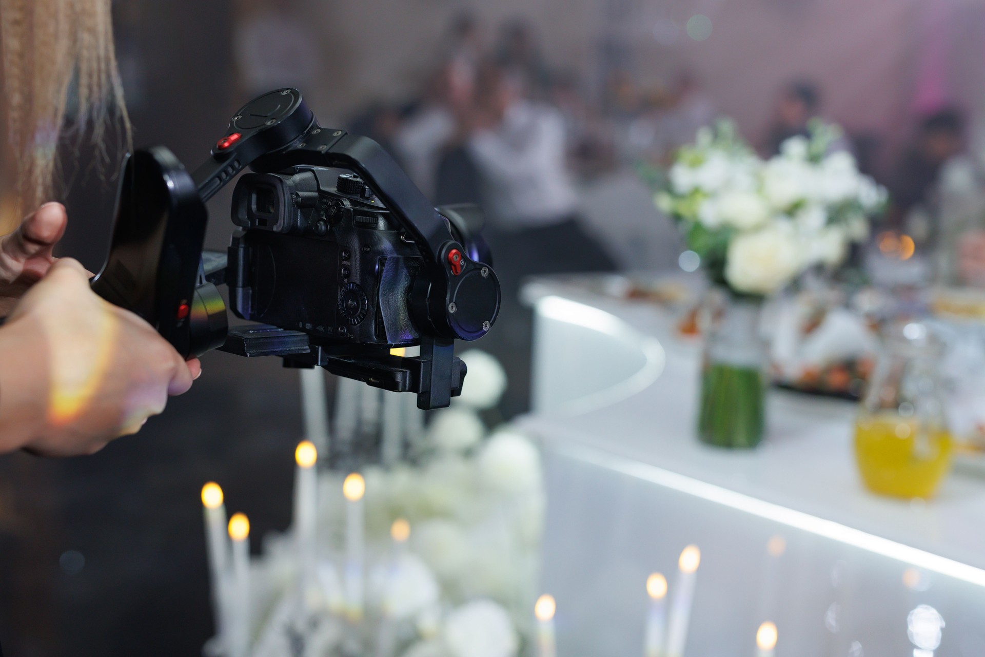 Cameraman filming a wedding reception with a professional video camera.