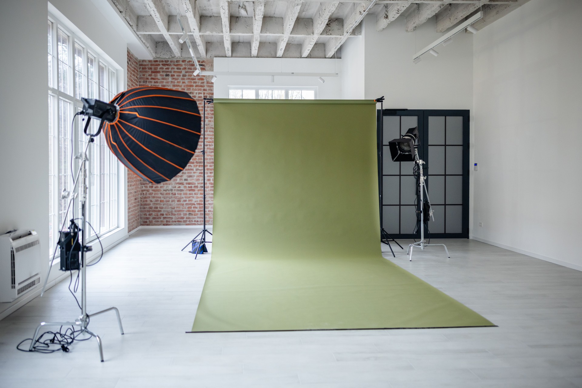 Empty photo studio with a green backdrop setup